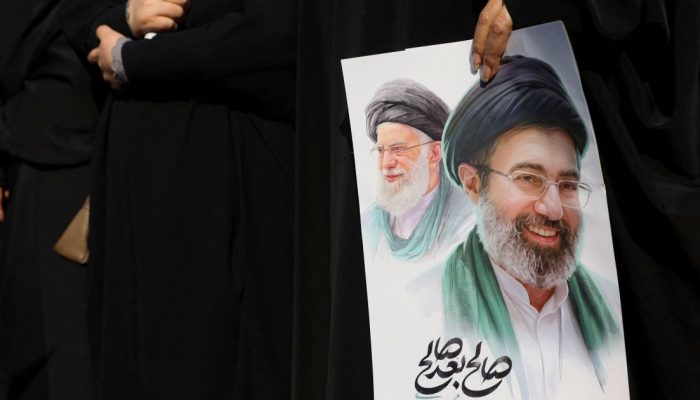 Mulher-segura-imagem-do-novo-lider-supremo-do-Ira-Mojtaba-Khamenei-e-do-lider-anterior-o-aiatola-Ali.jpeg